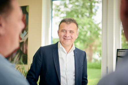 Karl Leutschaft, CEO der MConsult GmbH spricht in seinem Büro mit Mitarbeitern über Genehmigungsverfahren